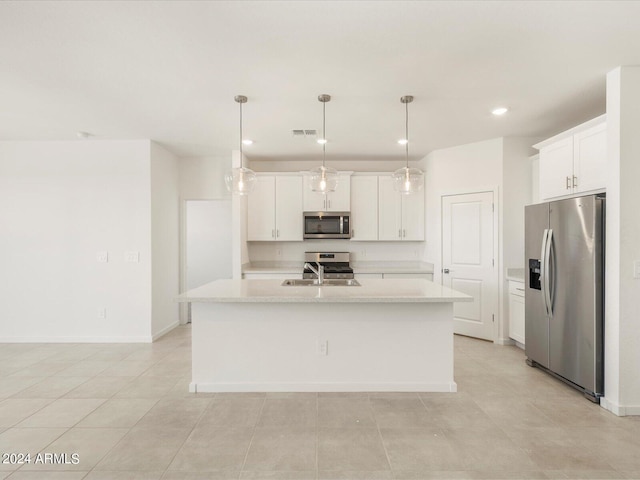 kitchen with a kitchen island with sink, decorative light fixtures, stainless steel appliances, and white cabinetry