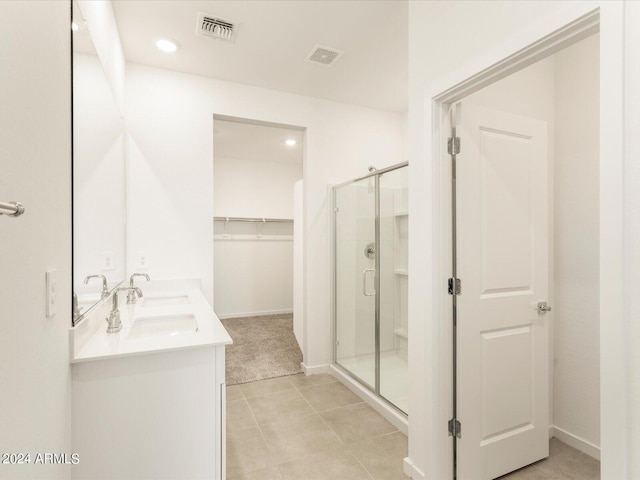 bathroom with vanity, a shower with shower door, and tile patterned floors