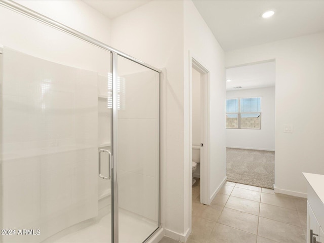 bathroom featuring vanity, toilet, tile patterned floors, and an enclosed shower