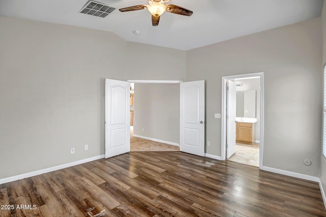 12441 W Windsor Blvd, Litchfield Park, AZ 85340 - unfurnished bedroom with wood finished floors, lofted ceiling, baseboards, connected bathroom, and a ceiling fan