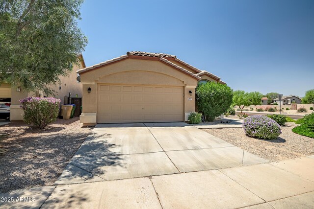 12441 W Windsor Blvd, Litchfield Park, AZ 85340 - mediterranean / spanish-style home featuring stucco siding, driveway, a tiled roof, and a garage
