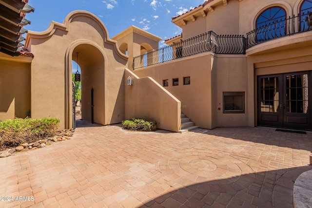 property entrance with a balcony and french doors