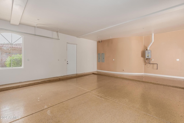 garage featuring electric panel and tankless water heater