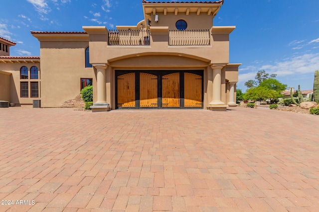 rear view of house featuring a balcony and cooling unit