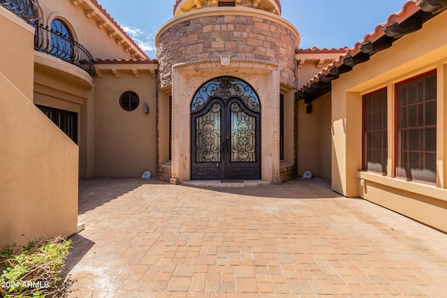 property entrance featuring a balcony and french doors