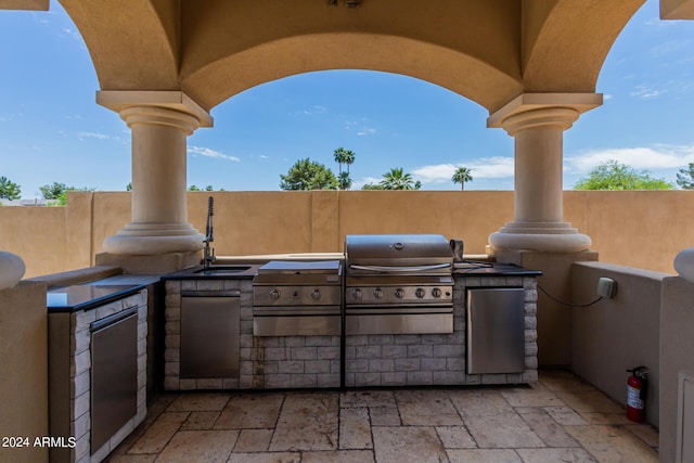 view of patio / terrace featuring an outdoor kitchen and a grill