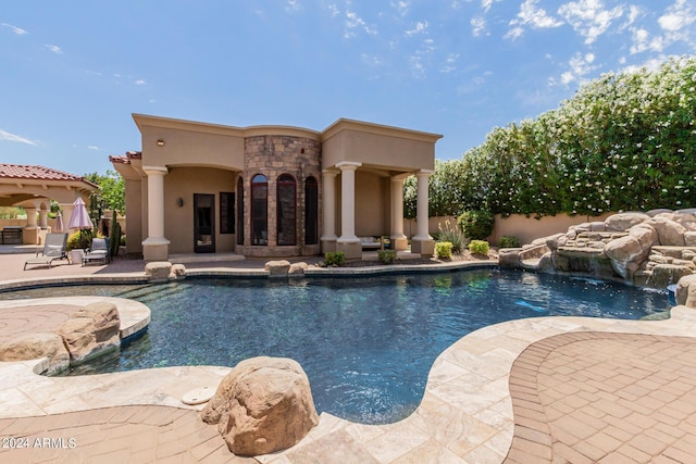 view of swimming pool featuring pool water feature and a patio area