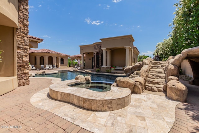 view of swimming pool featuring an in ground hot tub and a patio