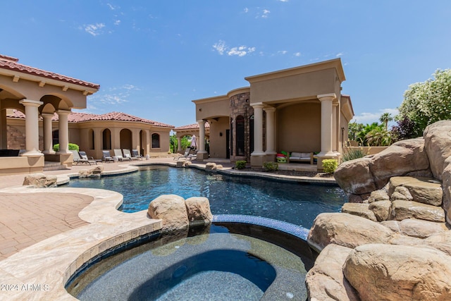 view of pool featuring a patio area and an in ground hot tub