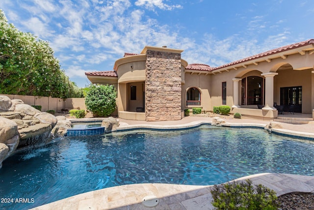 view of swimming pool with a patio area, an in ground hot tub, and pool water feature