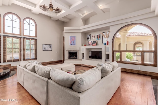 living room with beam ceiling, ceiling fan, and light hardwood / wood-style flooring