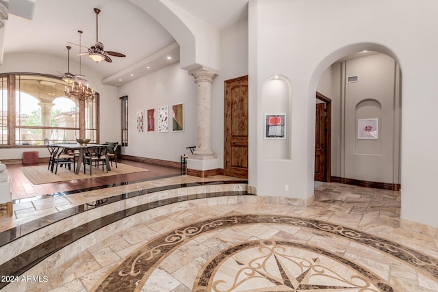 corridor with decorative columns and a towering ceiling