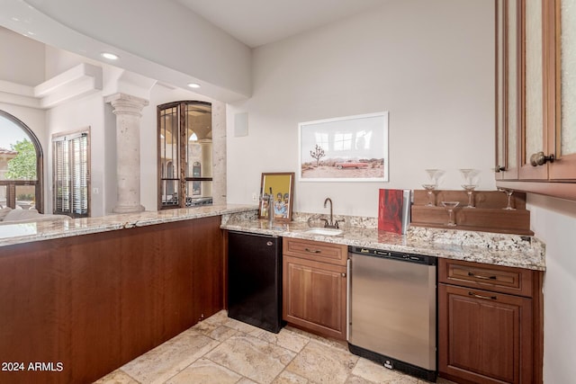 kitchen featuring ornate columns, light stone counters, sink, and appliances with stainless steel finishes