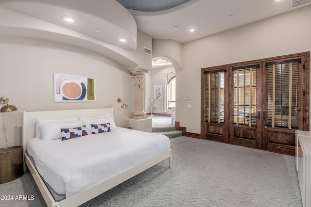 bedroom with light colored carpet and ornate columns