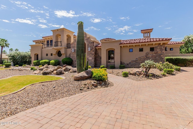 mediterranean / spanish house featuring a balcony