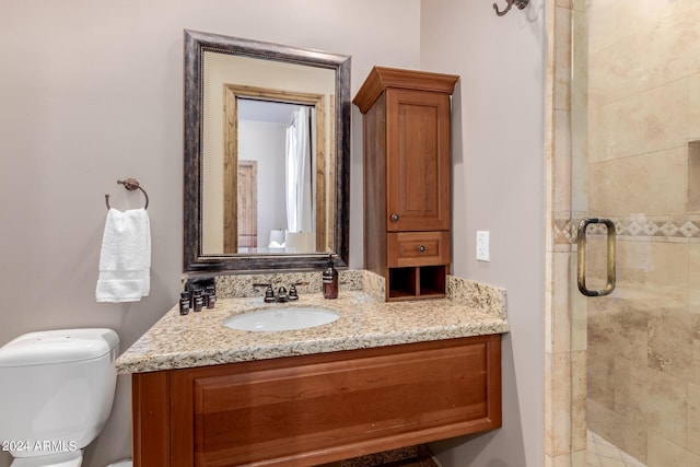 bathroom featuring vanity, toilet, and an enclosed shower