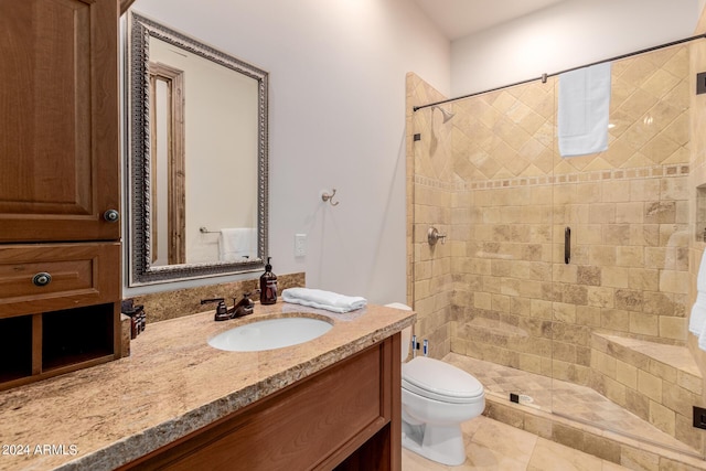 bathroom with tile patterned floors, vanity, an enclosed shower, and toilet