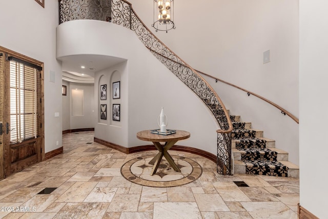 foyer featuring a towering ceiling and a chandelier