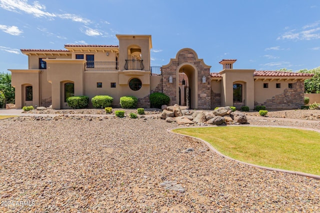 mediterranean / spanish house with a balcony and a front yard