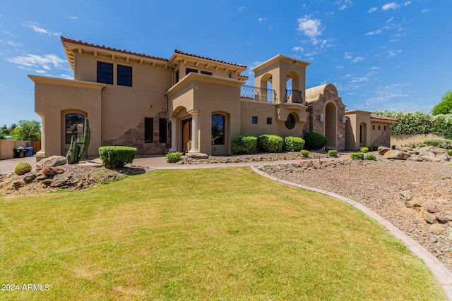 view of front of property featuring a balcony and a front lawn