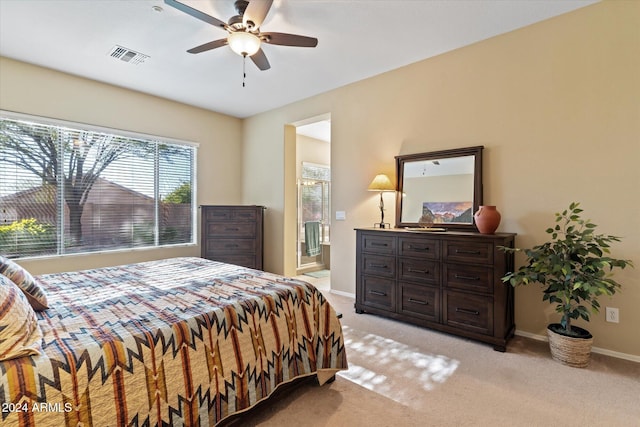 bedroom with connected bathroom, ceiling fan, and light carpet