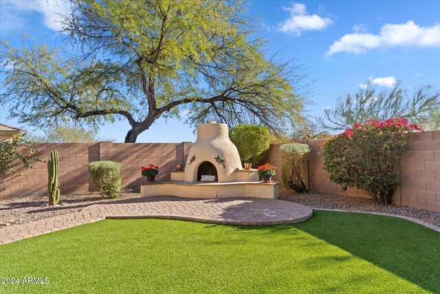 view of yard featuring a patio area and an outdoor fireplace