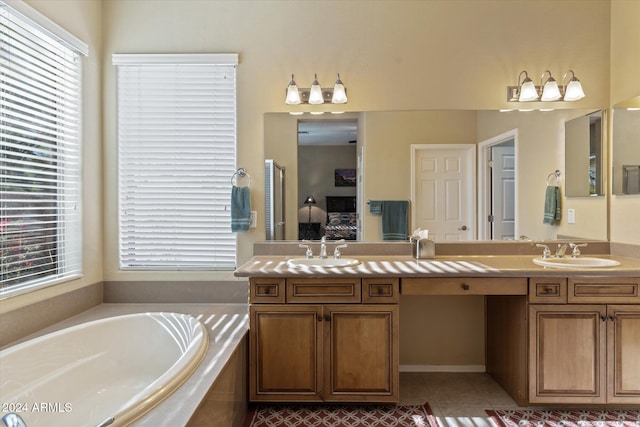 bathroom with tile patterned flooring, vanity, and a relaxing tiled tub