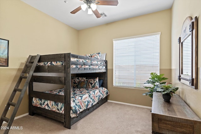 bedroom with multiple windows, ceiling fan, and light colored carpet