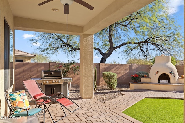 view of patio / terrace with ceiling fan and an outdoor fireplace