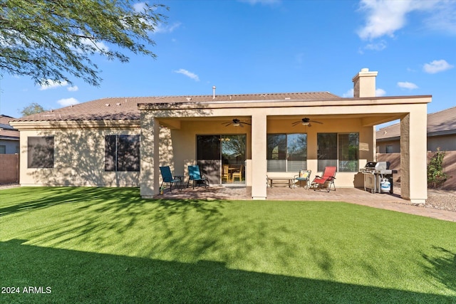 rear view of house with a patio area, ceiling fan, and a yard