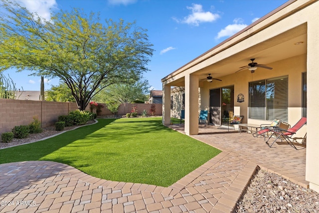 view of yard with ceiling fan and a patio