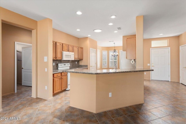 kitchen with white appliances, visible vents, decorative backsplash, stone counters, and a notable chandelier