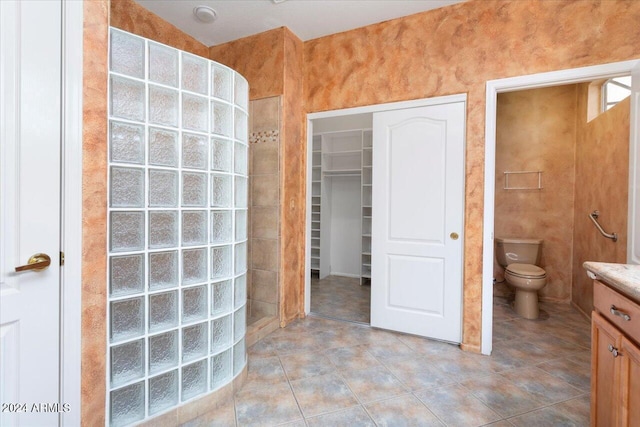 full bath with vanity, walk in shower, toilet, and tile patterned floors