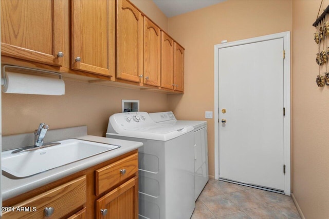 laundry room with cabinet space, washing machine and dryer, light tile patterned flooring, a sink, and baseboards