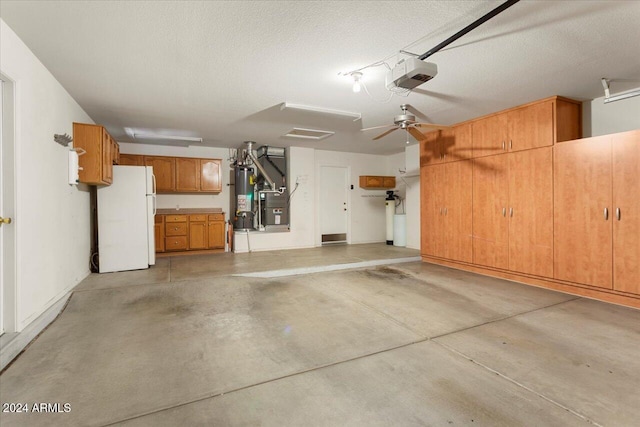 garage featuring a garage door opener, gas water heater, and freestanding refrigerator