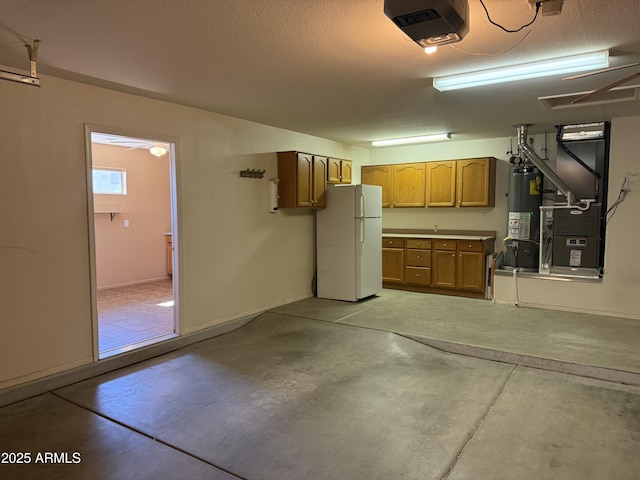 garage with a garage door opener, freestanding refrigerator, gas water heater, and heating unit