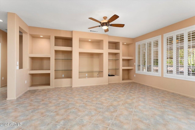 unfurnished living room with ceiling fan, built in shelves, tile patterned flooring, visible vents, and baseboards