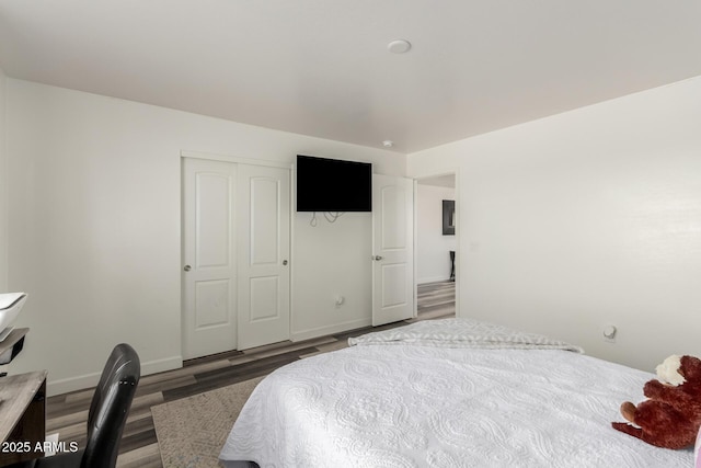 bedroom with a closet and dark hardwood / wood-style flooring