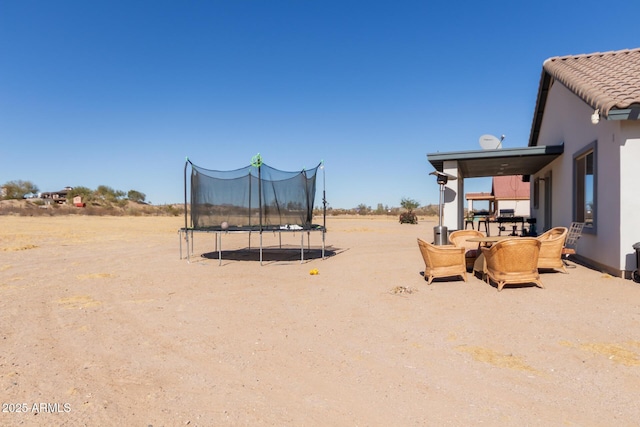 view of yard featuring a patio and a trampoline