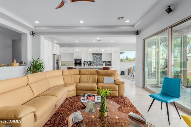 living room with ceiling fan and light wood-type flooring