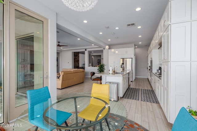 dining room featuring ceiling fan, a barn door, and sink