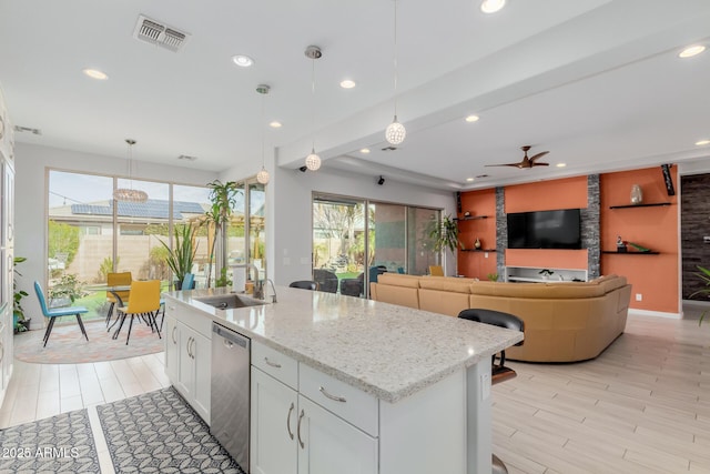 kitchen with pendant lighting, sink, white cabinets, a kitchen island with sink, and stainless steel dishwasher