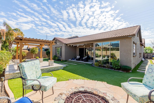 back of house featuring an outdoor fire pit, a pergola, a patio area, and a lawn