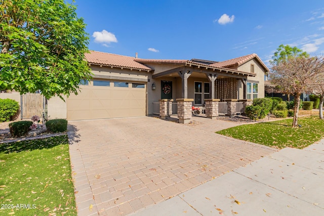 view of front of property with a garage, a front yard, and covered porch