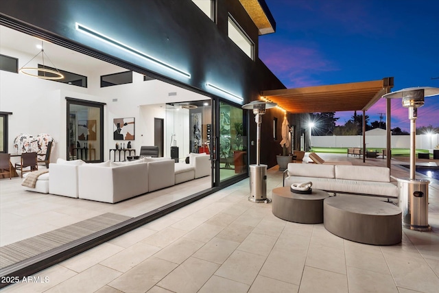 patio terrace at dusk with an outdoor hangout area and a pergola