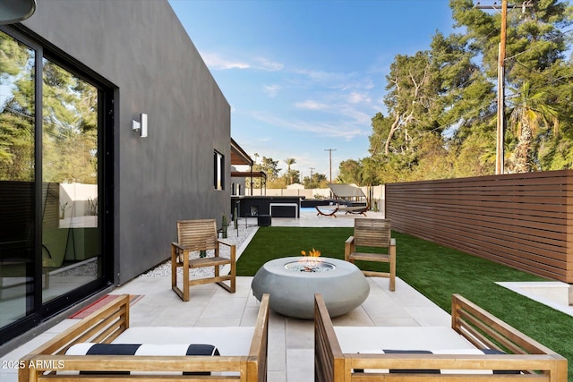 exterior space with a patio, a fenced backyard, and an outdoor fire pit