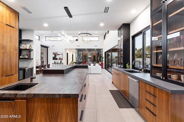 kitchen with light tile patterned floors, modern cabinets, visible vents, and a sink