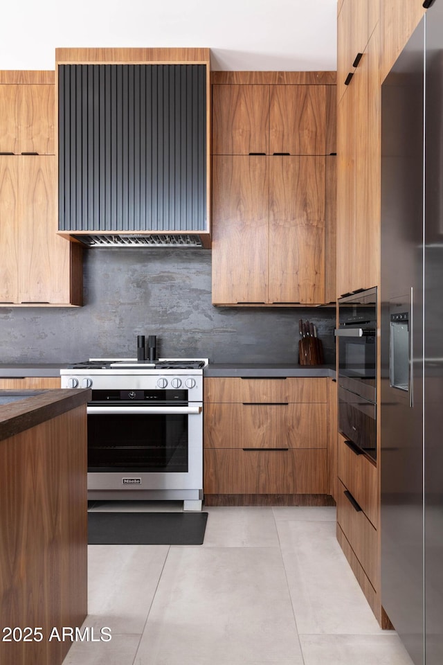 kitchen with dark countertops, modern cabinets, and appliances with stainless steel finishes