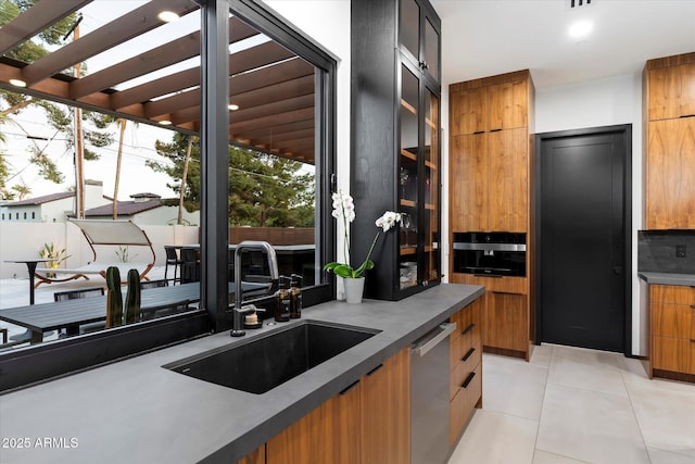 kitchen with a sink, tasteful backsplash, stainless steel dishwasher, and modern cabinets