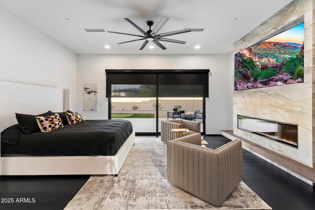 bedroom with access to exterior, visible vents, a premium fireplace, recessed lighting, and wood finished floors